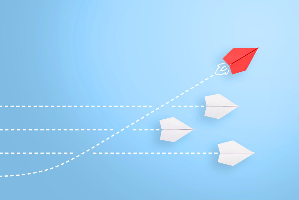 Group of paper plane in one direction and with one individual pointing in the different way, can be used leadership/individuality concepts. New idea, change, trend, courage, creative solution, innovation and unique way concept.